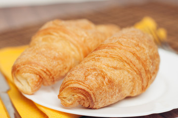 croissants, knife and yellow napkin