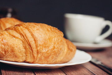 croissant plates and cup and saucer in the background