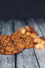 oatmeal cookies covered with chocolate and shortbread cookies on a wooden table