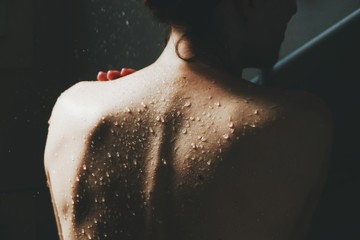 Schiena di donna sotto la doccia