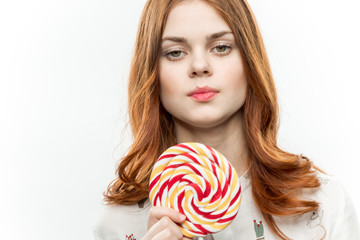 beautiful woman with a lollipop in hands on a white background