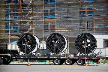 Obraz premium semi truck with cable reels at construction site with scaffolding 