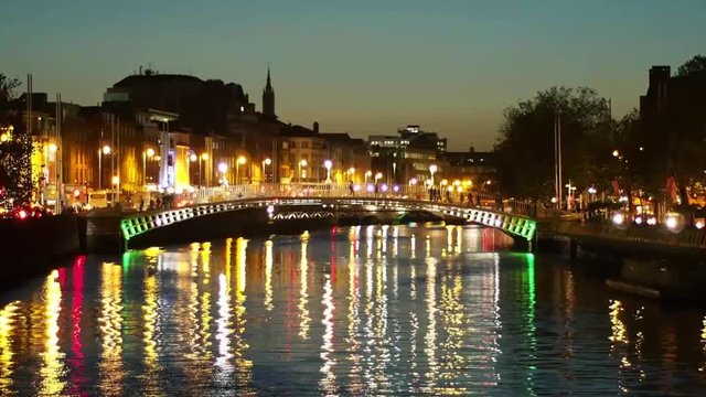 Night View of the Ha'penny Bridge Over Liffey River in Dublin, Ireland. Night Cityscape With Colourful Light Reflection on the Water Surface. Hapenny Bridge, Nigthtime.