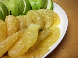 Grapefruit and Guava in white dish on wood table