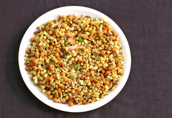 Germinated healthy seeds on the black background in white plate.