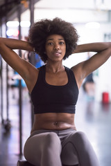Fototapeta na wymiar black woman doing sit ups at the gym