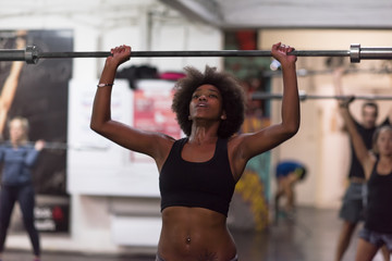 Naklejka premium black woman lifting empty bar