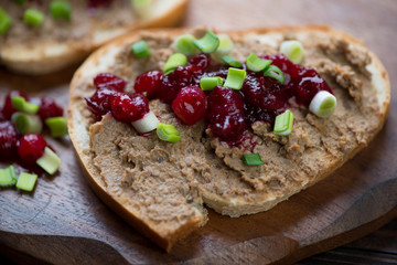 Slice of white bread with chicken liver pate, cranberry sauce and green onion, closeup
