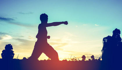 man training karate on sunset.