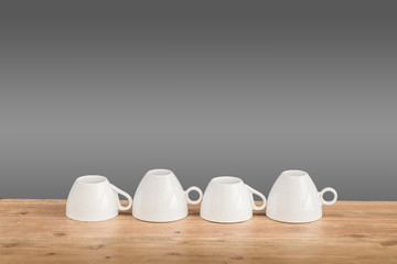 White coffee cups on the wooden table with grey background