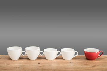 Different coffee cups on the wooden table with grey background