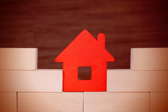 Red Toy Paper House Stands On A Wooden Bricks