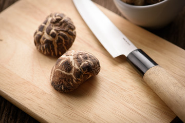 Fototapeta na wymiar dried shiitake mushroom on wood block for food background