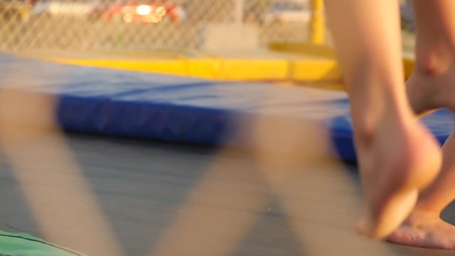 legs of kids running and jumping on the trampoline