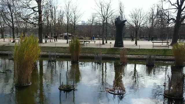 Tourists in beautiful park in Paris, France. Les Jardins des Tuileries in Paris. Small pond in the middle of the park