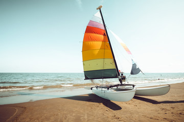 Vintage colorful sailboat on tropical beach in summer. retro color tone effect