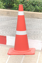 The traffic cone on the road.