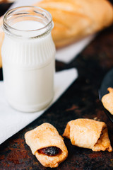Nice breakfast - milk with croissants on black rustic surface.