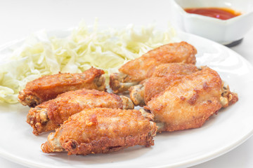 Chicken wings in plate with tomato sauce.