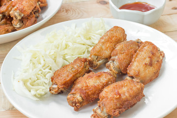 Chicken wings in plate with and cabbage alley.