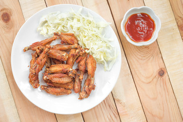 Chicken wings in plate with tomato sauce.