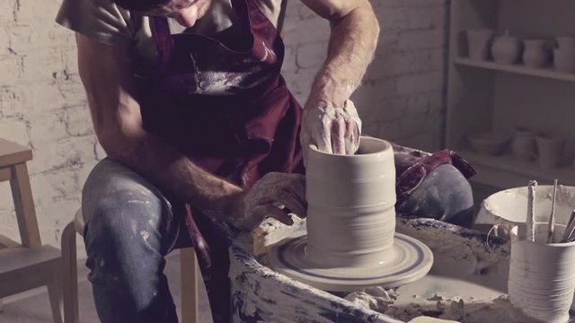 Master models vase on a potter