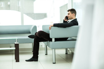 successful businessman sits in the lobby of a modern office
