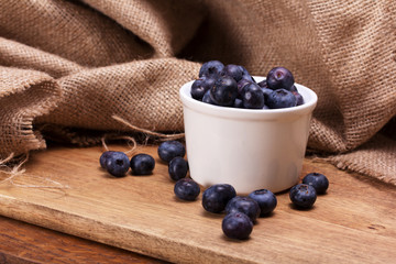 Pot of blueberries on a rustic background