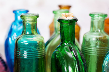 Coloured glass bottles on a rustic background
