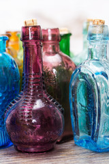 Coloured glass bottles on a rustic background