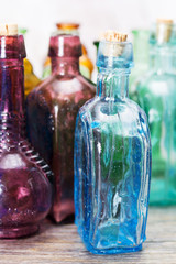 Coloured glass bottles on a rustic background