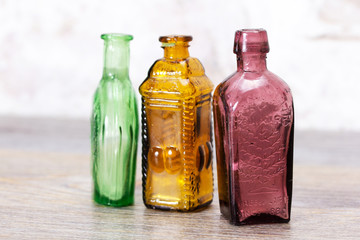 Coloured glass bottles on a rustic background
