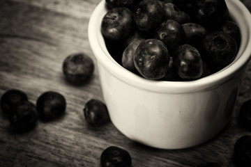 Pot of blueberries on a rustic background