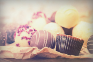 Selection of delicious chocolates on a rustic background