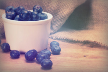 Pot of blueberries on a rustic background