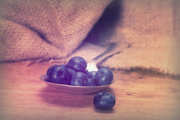 Blueberries and spoon on a rustic background