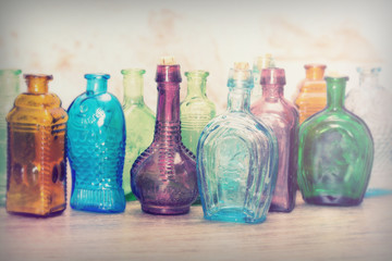 Coloured glass bottles on a rustic background