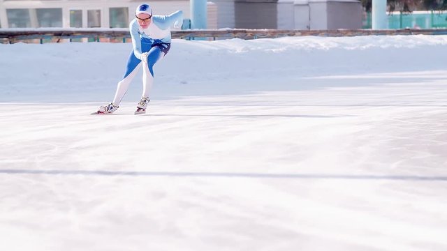 Speed ice skater skating on outdoor race on turn HD slow-motion video. Professional athlete training for winter olympic. View of legs on skates