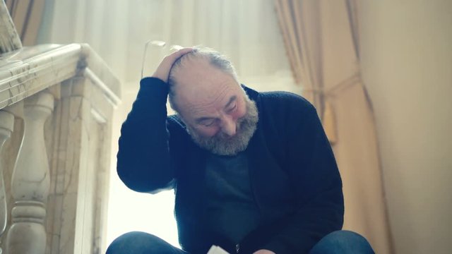 Tired angry old man stands up and gathering papers in 4K