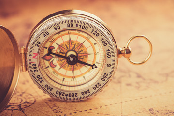 Fototapeta na wymiar Old gold vintage compass on vintage map