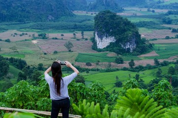 Woman taking photo with smartphone at mountain, beautiful view from Thailand.