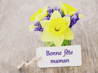 Naklejka premium petit bouquet de printemps avec jonquilles dans vase,et pancarte bonne fête maman