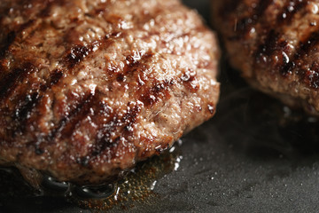 beef cutlets rest on frying pan, shallow focus