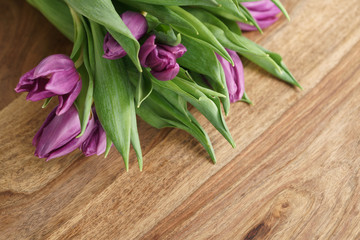 bouquet of purple tulips on wood table with copy space, shallow focus