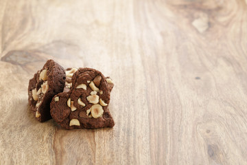 homemade heart shaped chocolate cookies with hazelnuts on wood table, shallow focus