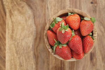 fresh strawberries in bowl on wood table, organic garden berries