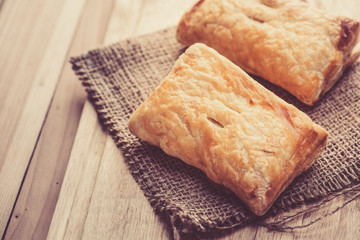 Pies of puff pastry close up on an sack background