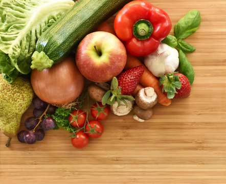 Fresh vegetables and fresh fruit on a wooden tablet. Healthy eating background with copy space. High angle view.