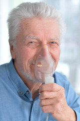 Sick elderly man makes inhalation