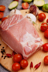 Raw pork on cutting board and vegetables 